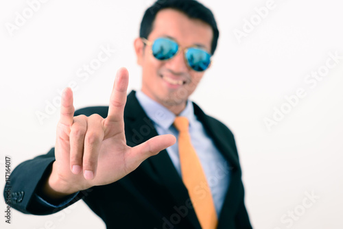 Businessman in black suit showing hand in love sign.