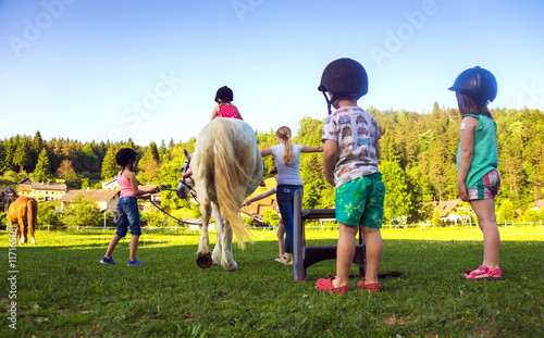 Fototapeta Naklejka Na Ścianę i Meble -  Children riding  horse, horse riding school