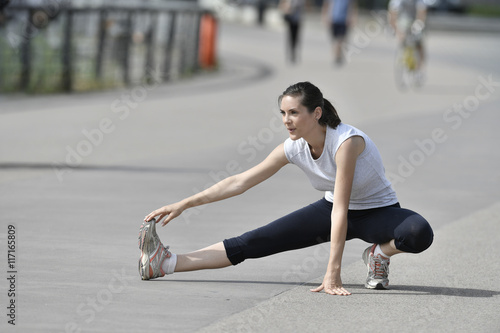 Fitness girl stretching after running
