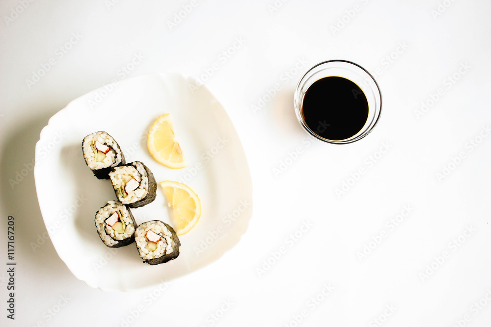 Sushi maki with lemon slices on the white plate Sushi maki with lemon slices on the white plate