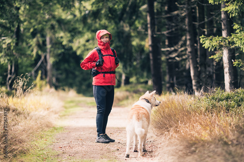 Happy woman hiking with dog in woods