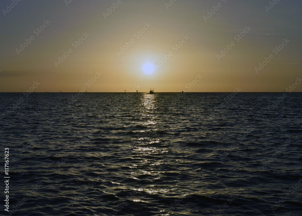 Obraz premium A boat coming in at sunset at Hudson beach, Hudson, Florida.