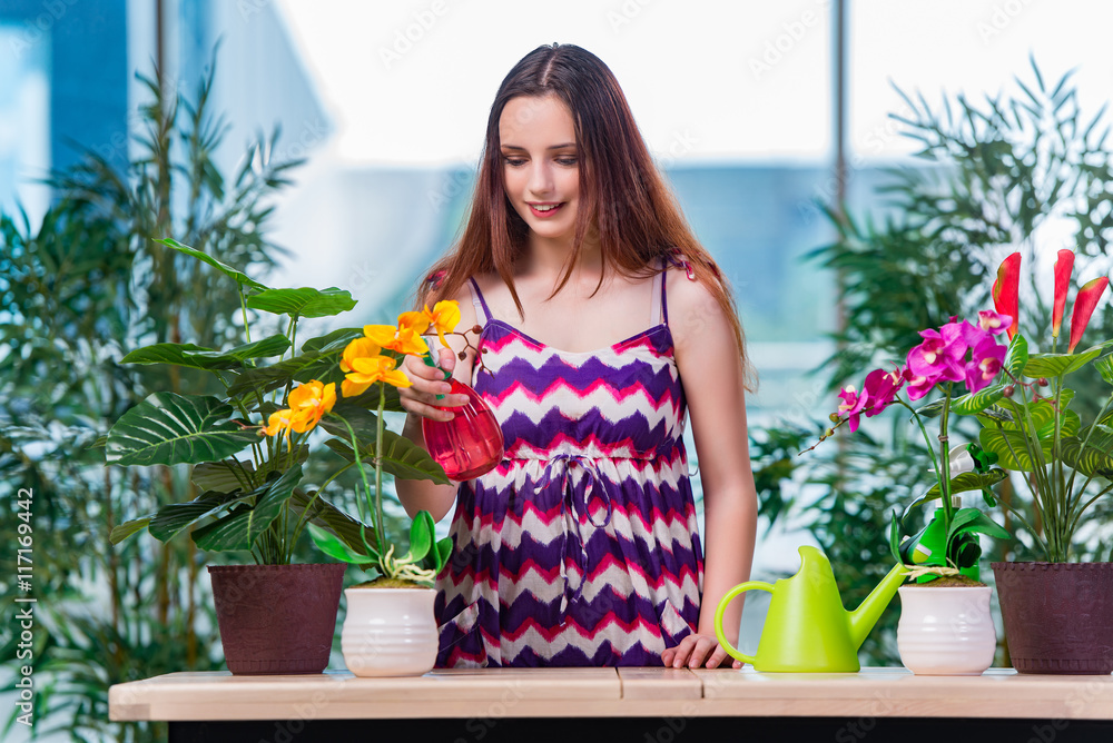 Young woman taking care of home plants