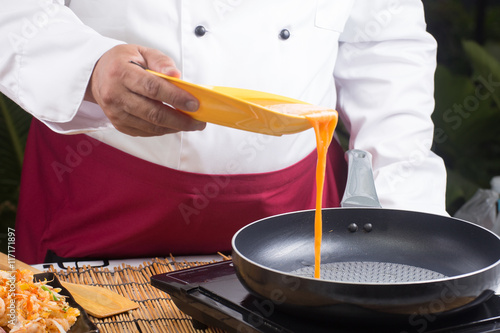 chef pouring egg to pan