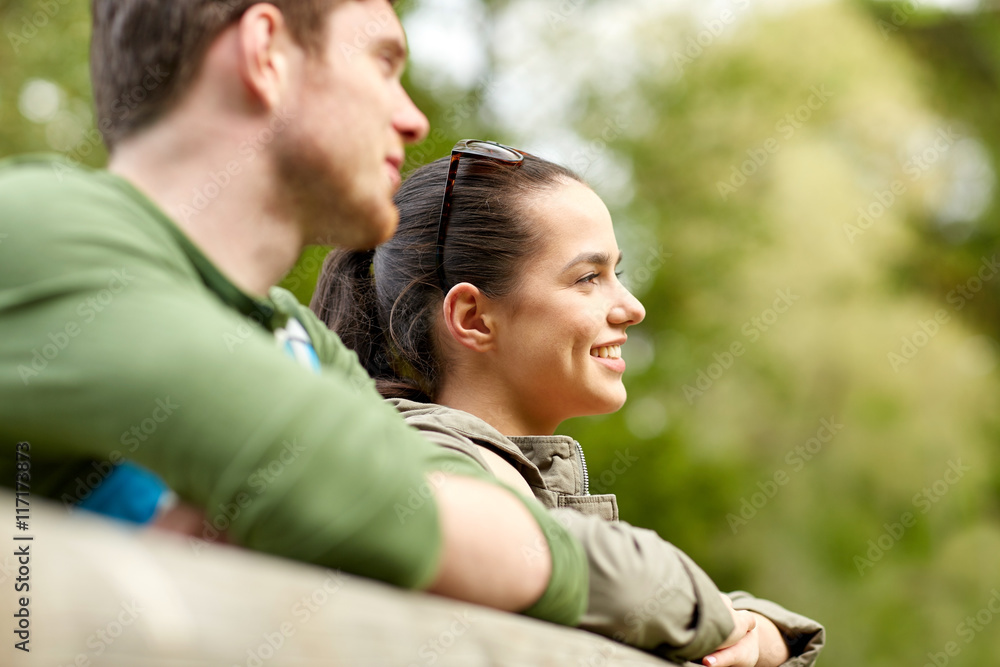 smiling couple with backpacks on bridge in nature smiling couple with backpacks on bridge in nature