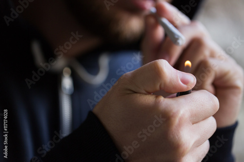 close up of addict lighting up marijuana joint