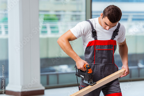 Young carpenter working at construction site