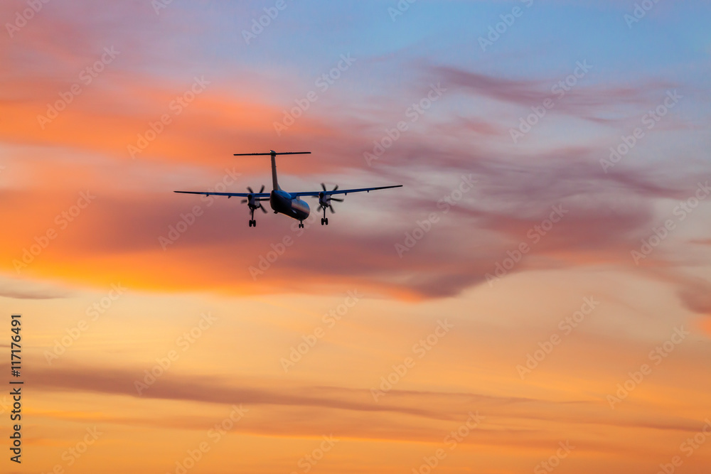 Airplane landing in airport at sunset