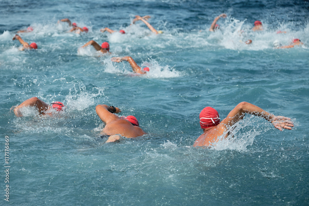 Group people in wetsuit swimming at sea