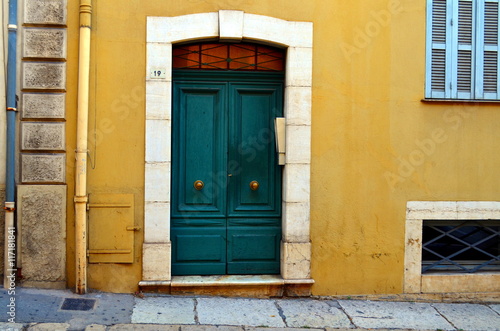 green front door of a yellow house