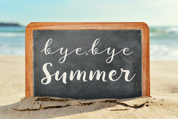 text bye, bye summer in a chalkboard on the beach