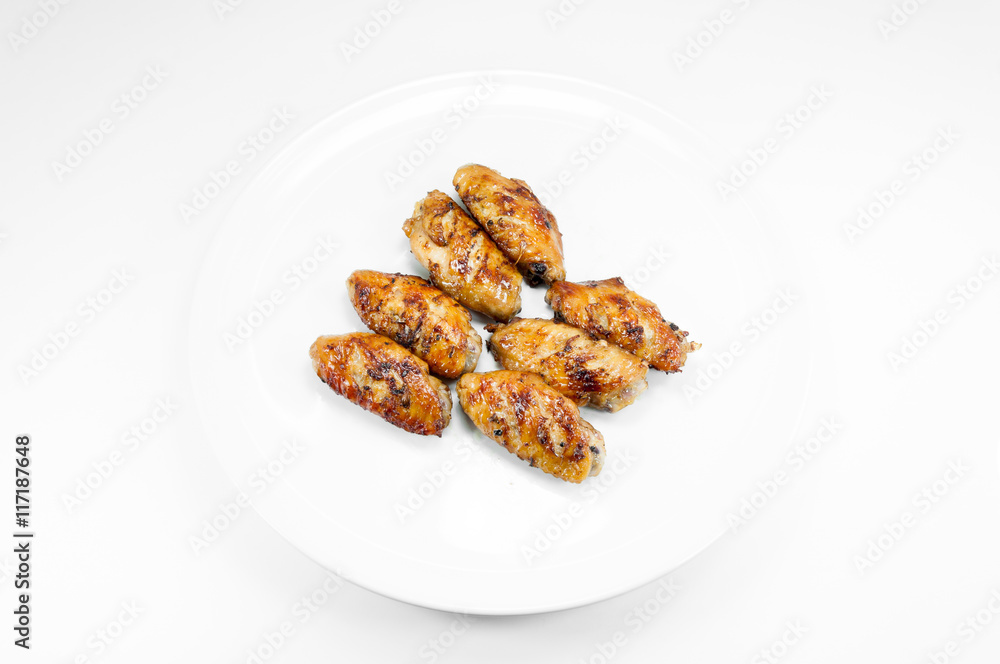 Grilled chicken wings in dish white on white background Grilled chicken wings in dish white on white background