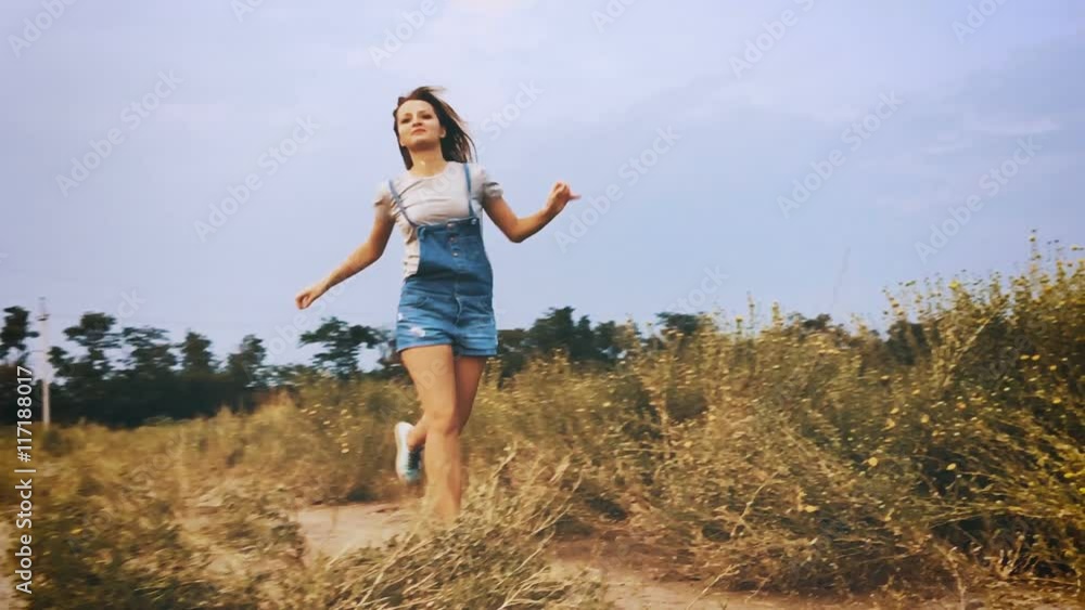 Happy girl running towards the wind turbine, slow motion. Happy girl running towards the wind turbine, slow motion.