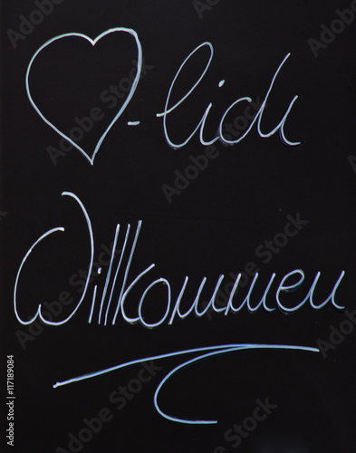 Schriftzug herzlich willkommen auf schwarzer Tafel