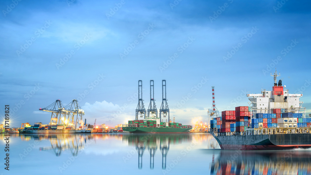 Logistics and transportation of International Container Cargo ship in a harbor with water reflections for logistic import export background and transport industry. Logistics and transportation of International Container Cargo ship in a harbor with water reflections for logistic import export background and transport industry.