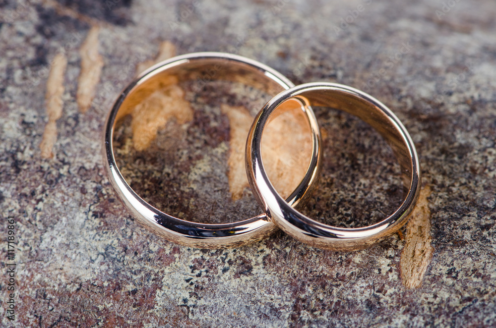 Two gold wedding rings on wooden background Two gold wedding rings on wooden background