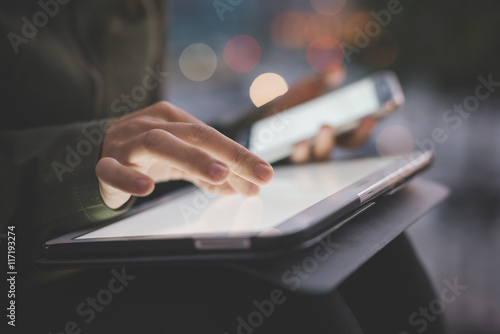 Close up on the hand of young handsome caucasian woman pointing and touching the screen of a tablet with her finger - technology, social network, communication concept