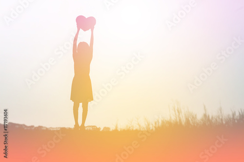 a silhouette of a happy young girl child the arms of his loving
