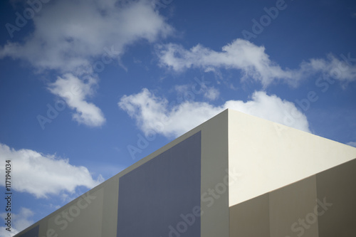 blue sky and clouds with a corner part of modern building selective focus dark edges