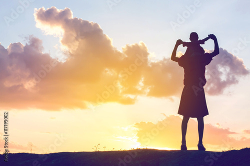 Mother encouraged her son outdoors at sunset  silhouette concept