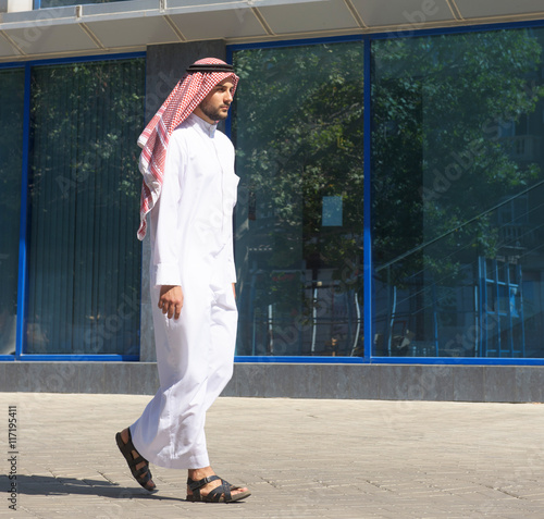 Handsome arabian man walking along the street
