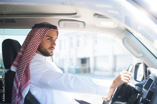 Portrait of a handsome arabian man driving a car