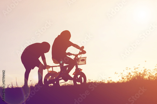 Fototapeta Naklejka Na Ścianę i Meble -  two little boys bike silhouette
