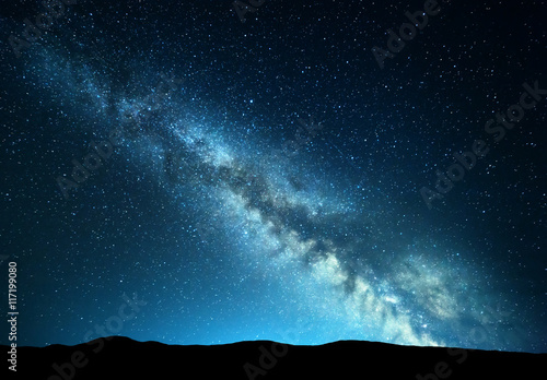 Night landscape with amazing Milky Way at mountains. Blue night starry sky with hills at summer. Beautiful Galaxy. Universe. Space background