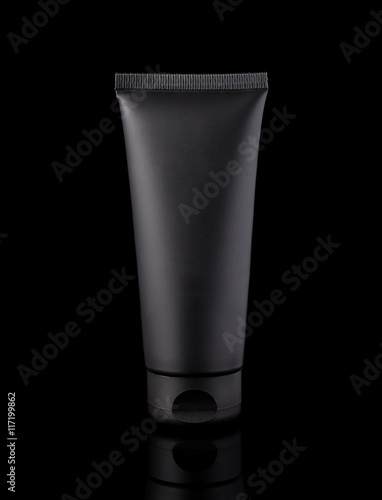 Black cosmetic tube, studio photography of black plastic tube for cream, isolated on black background
