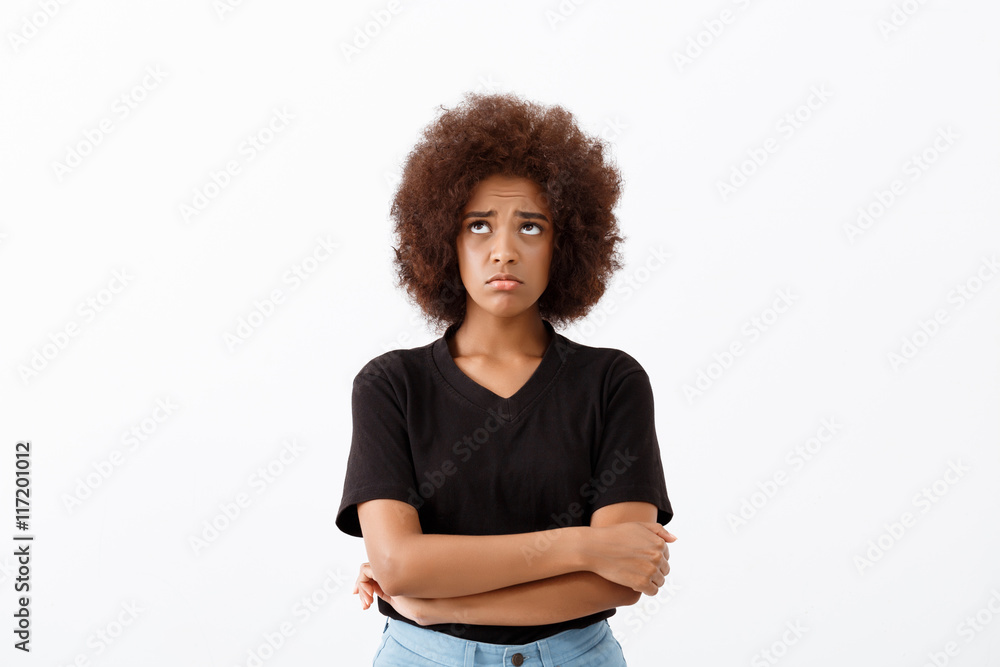Upset beautiful african girl over light background. Upset beautiful african girl over light background.