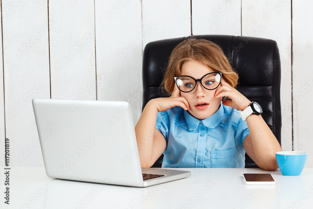 Tired young beautiful girl sitting at working place in office.