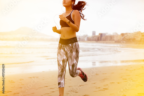 Fototapeta Naklejka Na Ścianę i Meble -  Young female body running along beach