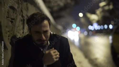 Young man crying on street. There is snow