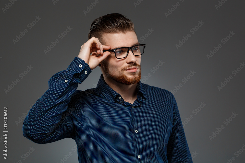 Fototapeta premium Young successful businessman posing over dark background. Copy space.