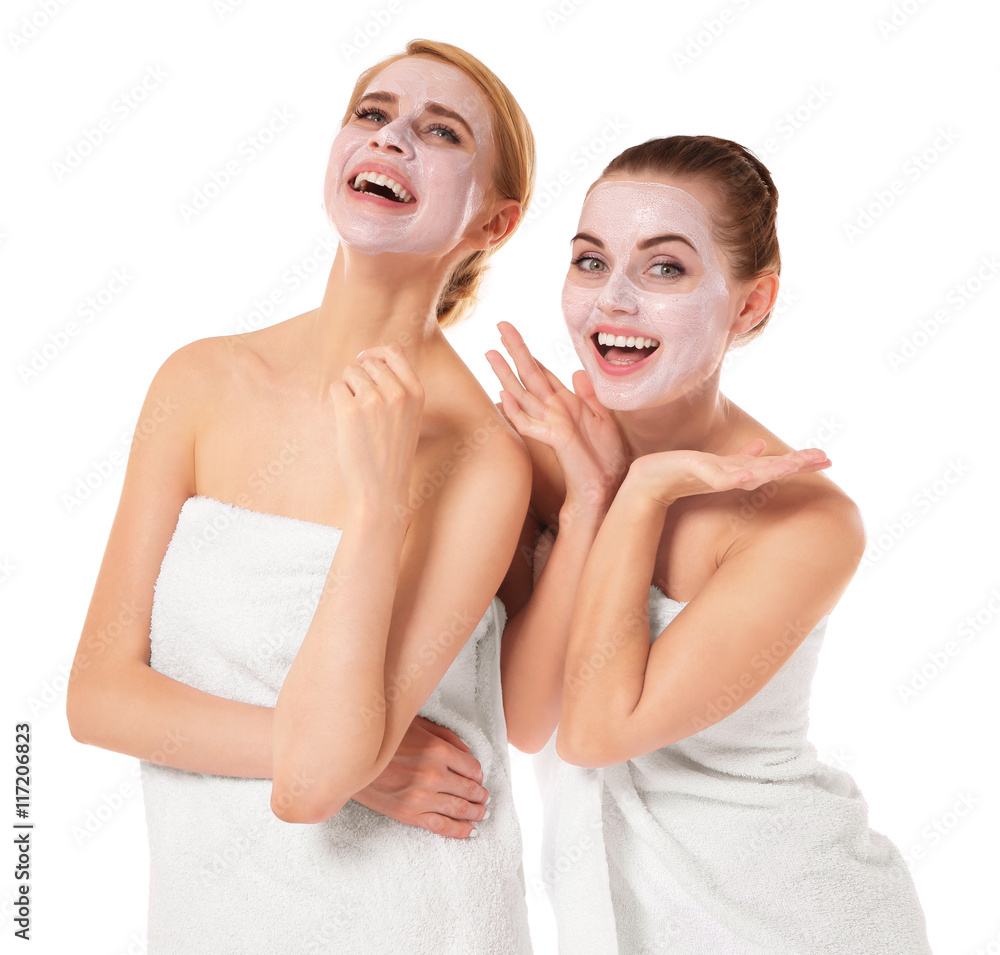 Two beautiful women wrapped in towels isolated on white Two beautiful women wrapped in towels isolated on white