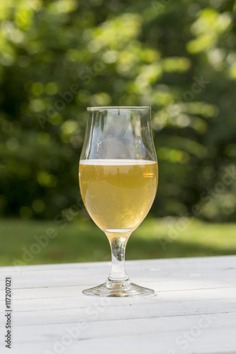 mug of beer on white table and green background