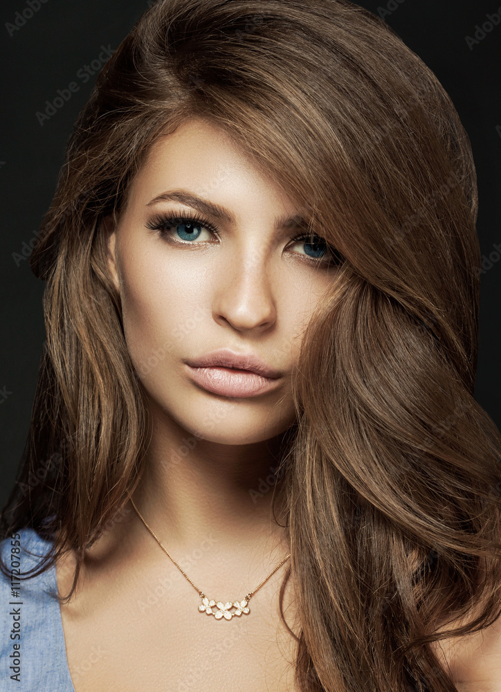 Beautiful young woman with long brown hair. Pretty model poses a