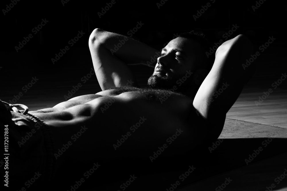Fototapeta premium Fitness model exercising sit ups and crunches. Muscular well bui