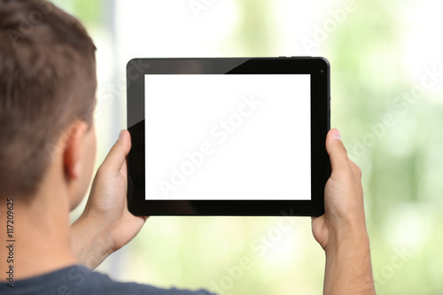 Young man with gadget on blurred background