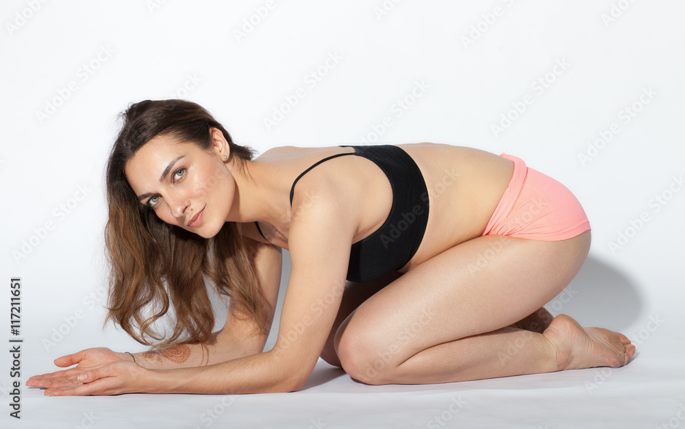 Young brunette woman doing pilates exercises isolated