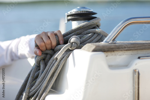 Yachtman hand pulling ropes photo