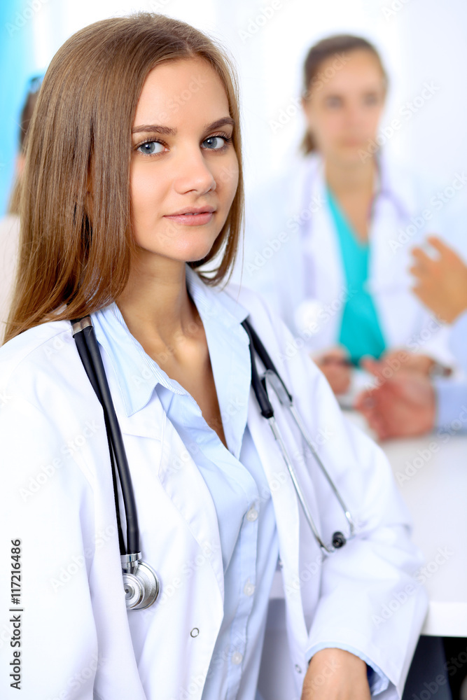 Happy doctor woman with medical staff at the hospital sitting at the table and discussing medical history Happy doctor woman with medical staff at the hospital sitting at the table and discussing medical history