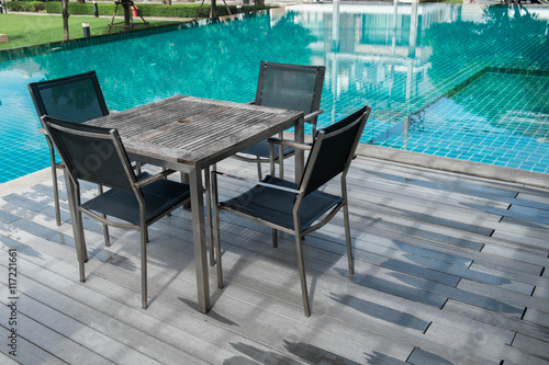 Table and chairs with swimming pool.