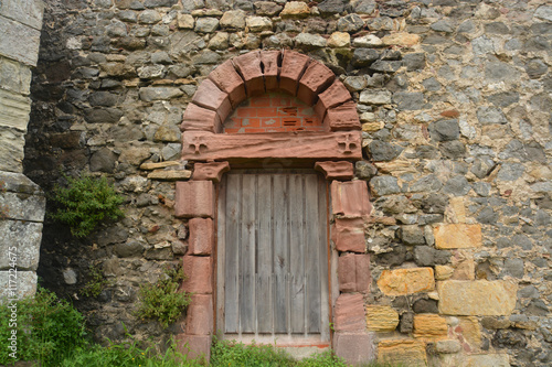 puerta antigua en un muro de piedra © uzkiland