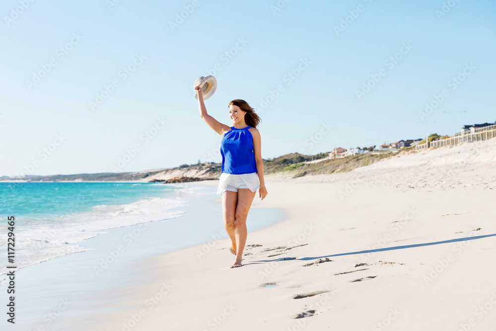 Young woman walking along the beach Young woman walking along the beach