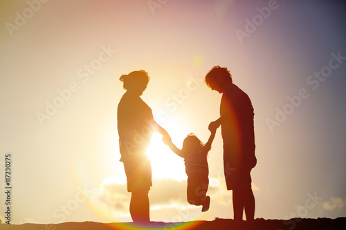 happy family play with little daughter at sunset