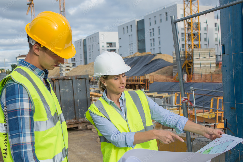 View of a Engineer and worker checking plan on construction site View of a Engineer and worker checking plan on construction site