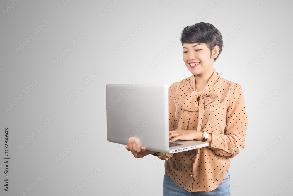 asian businesswoman using laptop on gray background. asian businesswoman using laptop on gray background.
