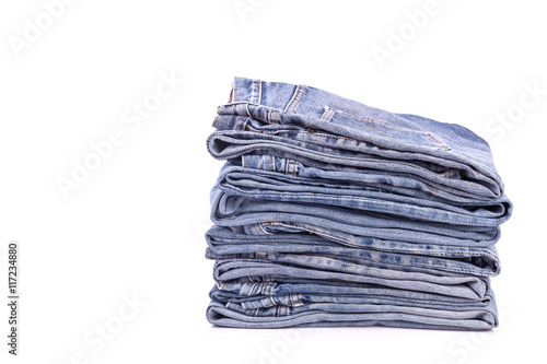 Stack of old blue jeans isolated on white