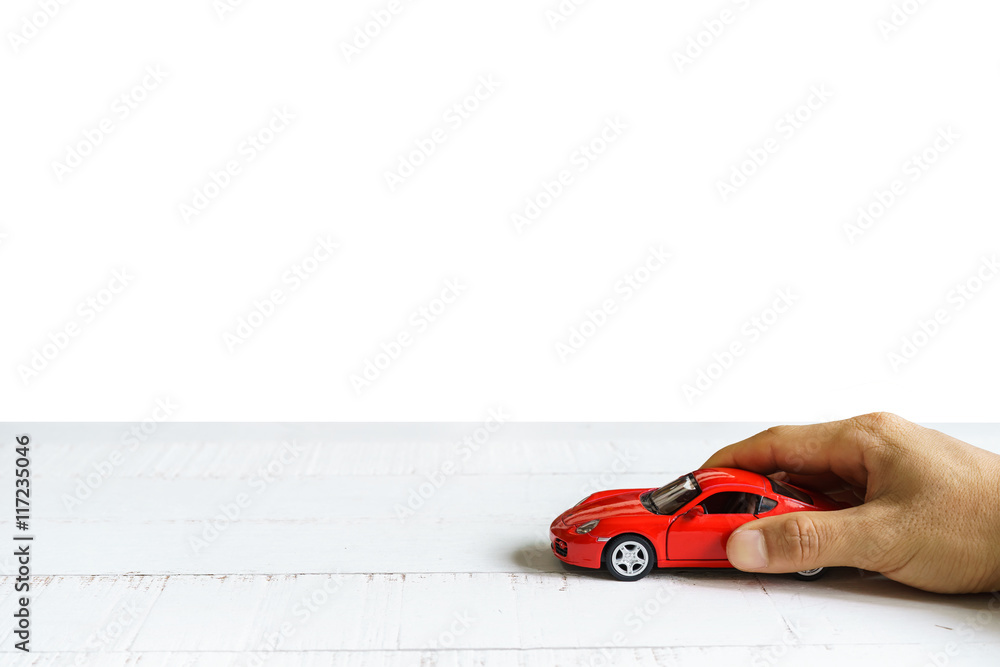 Car in hand on wooden table isolated on white background